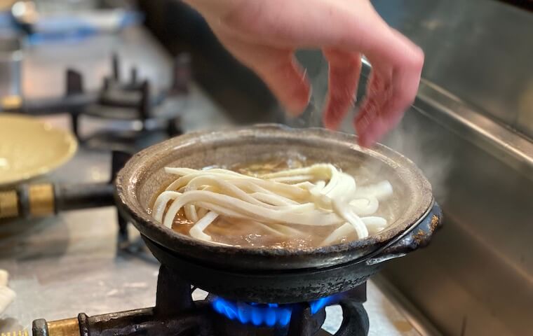 カレー煮込みうどんを土鍋の中で調理